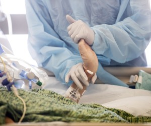 epa09679821 A nurse treats a Covid-19 patient, moving her fingers and wrists, in the ICU (Intensive Care Unit) of the Sharp Grossmont Hospital amid the coronavirus pandemic in La Mesa, East of San Diego, California, USA, 11 January 2022. The number of patients, who contracted the coronavirus, exploded in the recent weeks and US hospitals reportedly are currently caring for the highest number of patients since the beginning of the pandemic.  EPA/ETIENNE LAURENT  ATTENTION: This Image is part of a PHOTO SET