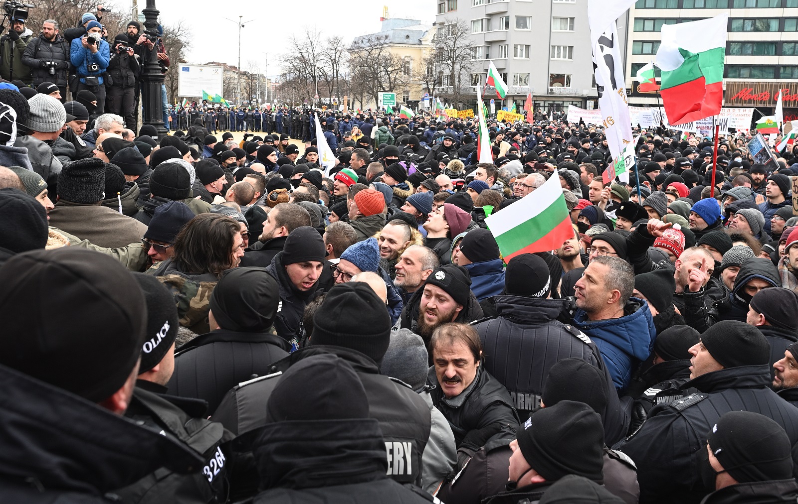 epa09680294 Police officers resist people during a protest against green certificate and vaccination against COVID-19 in fort of Bulgarian Parliament in Sofia, Bulgaria, 12 January 2022. People, gathered to protest against restrictive coronavirus measures, vaccinations and to demand the abolition of the green certificate, tried to invade the building of the legislature, entering into collisions with the police. According to police sources, several security agents and an indefinite number of protesters had to be evacuated as a result of the clashes after groups of citizens broke the security lines and began to hit the main entrance of Parliament, although the police were able to prevent their invasion. At the moment the confirmed wounded are four police officers who were taken to hospital for medical treatment and their status is unclear.  EPA/VASSIL DONEV