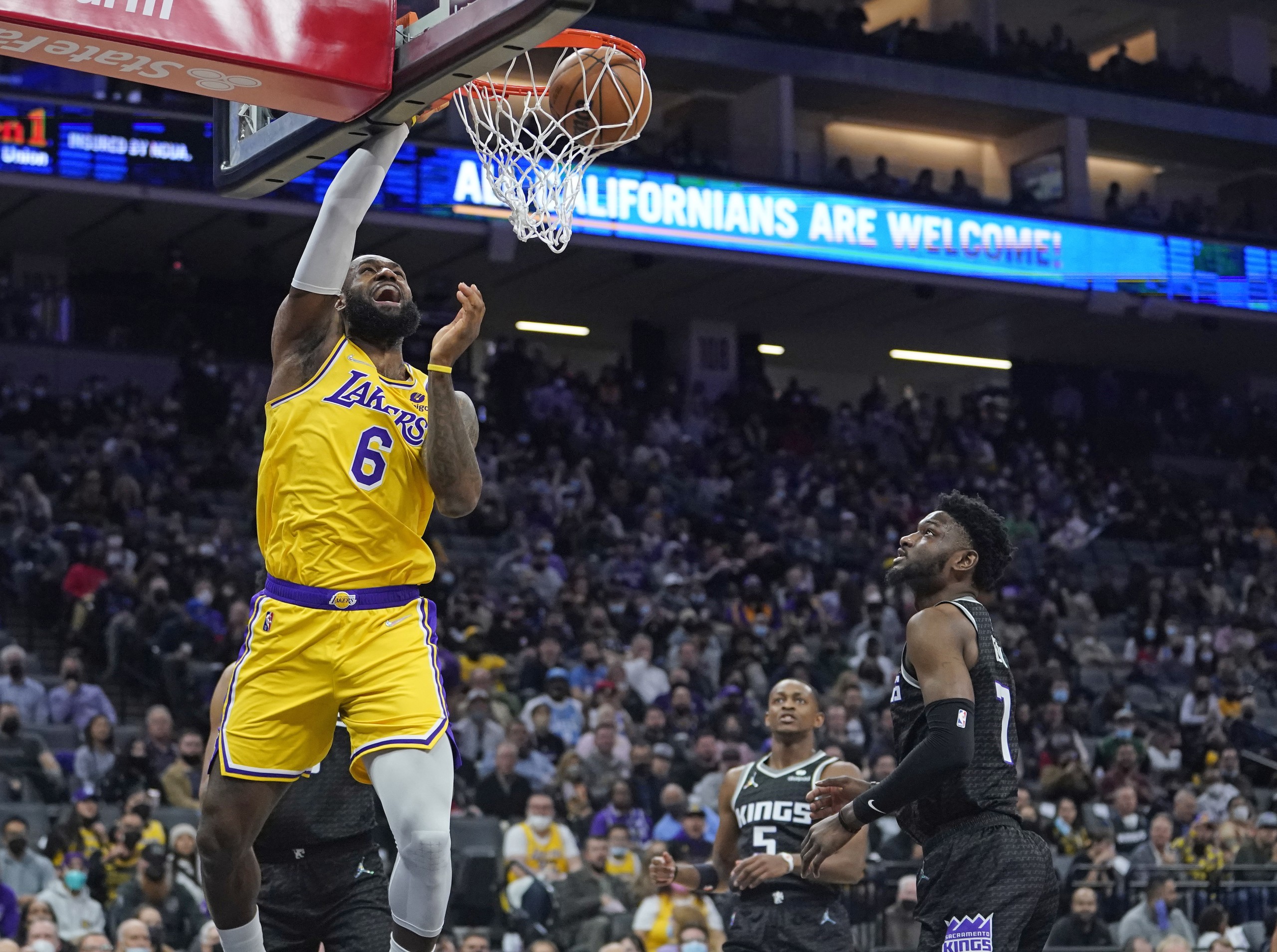 epa09681766 Los Angeles Lakers forward LeBron James (L) dunks the ball for two points as Sacramento Kings forward Chimezie Metu (R) looks on during the first half of their NBA game at Golden 1 Center in Sacramento, California, USA, 12 January 2022.  EPA/JOHN G. MABANGLO  SHUTTERSTOCK OUT