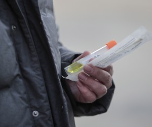 epa09684401 A man holds reagent as he wearing face mask lines up for COVID-19 tests in Beijing, China, 14 January 2022. The Chinese mainland on 13 January reported 143 new locally transmitted COVID-19 cases, the National Health Commission said in its daily report on 14 January 2022.  EPA/WU HONG