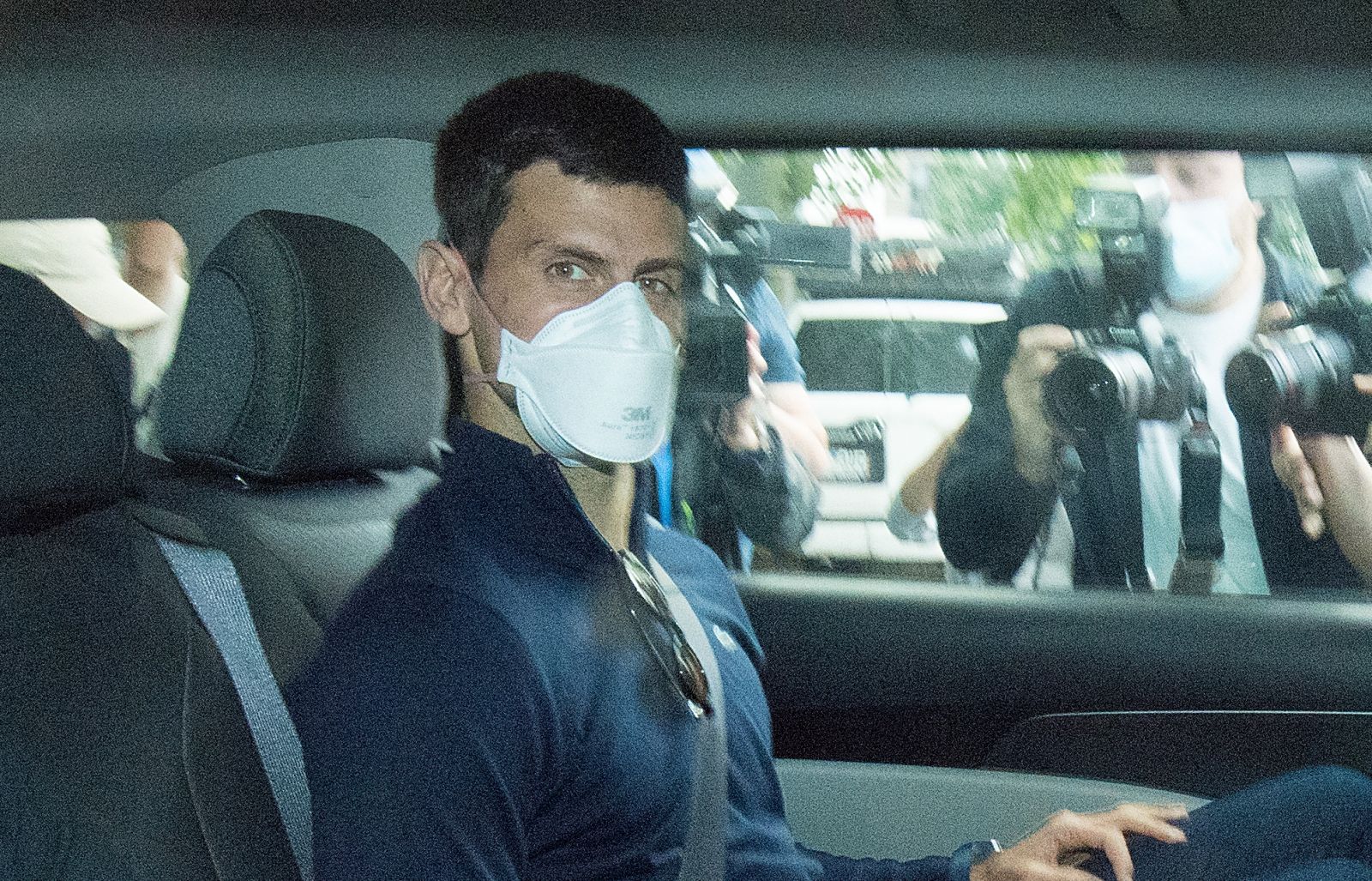 epa09688461 Serbian tennis player Novak Djokovic (C) departs from the Park Hotel government detention facility before attending a court hearing at his lawyers office in Melbourne, Australia, 16 January 2022. Novak Djokovic still faces uncertainty as to whether he can compete in the Australian Open, despite being announced in the tournament draw.  EPA/JAMES ROSS NO ARCHIVING AUSTRALIA AND NEW ZEALAND OUT