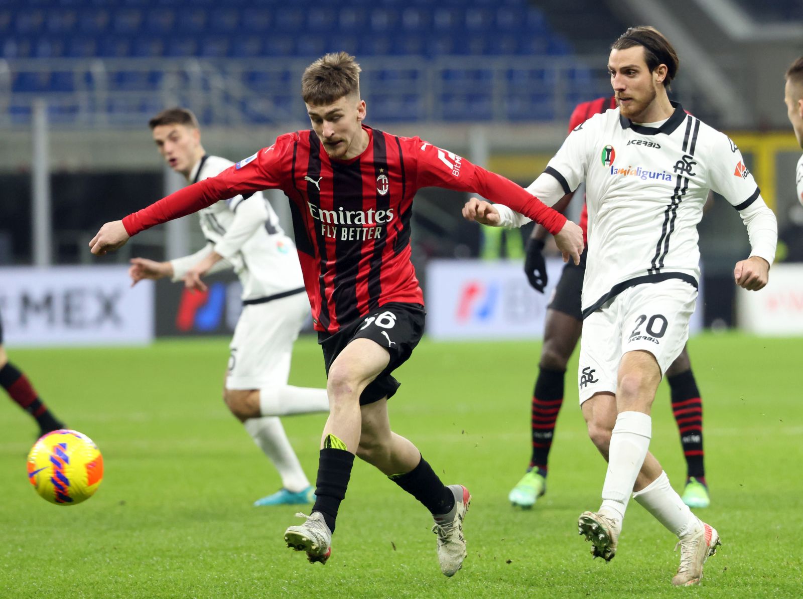 epa09691527 AC Milan’s Alexis Saelemaekers (L) challenges for the ball  Spezia’s Simone Bastoni during the Italian Serie A soccer match between AC Milan and Spezia at Giuseppe Meazza stadium in Milan, Italy, 17 January 2022.  EPA/MATTEO BAZZI
