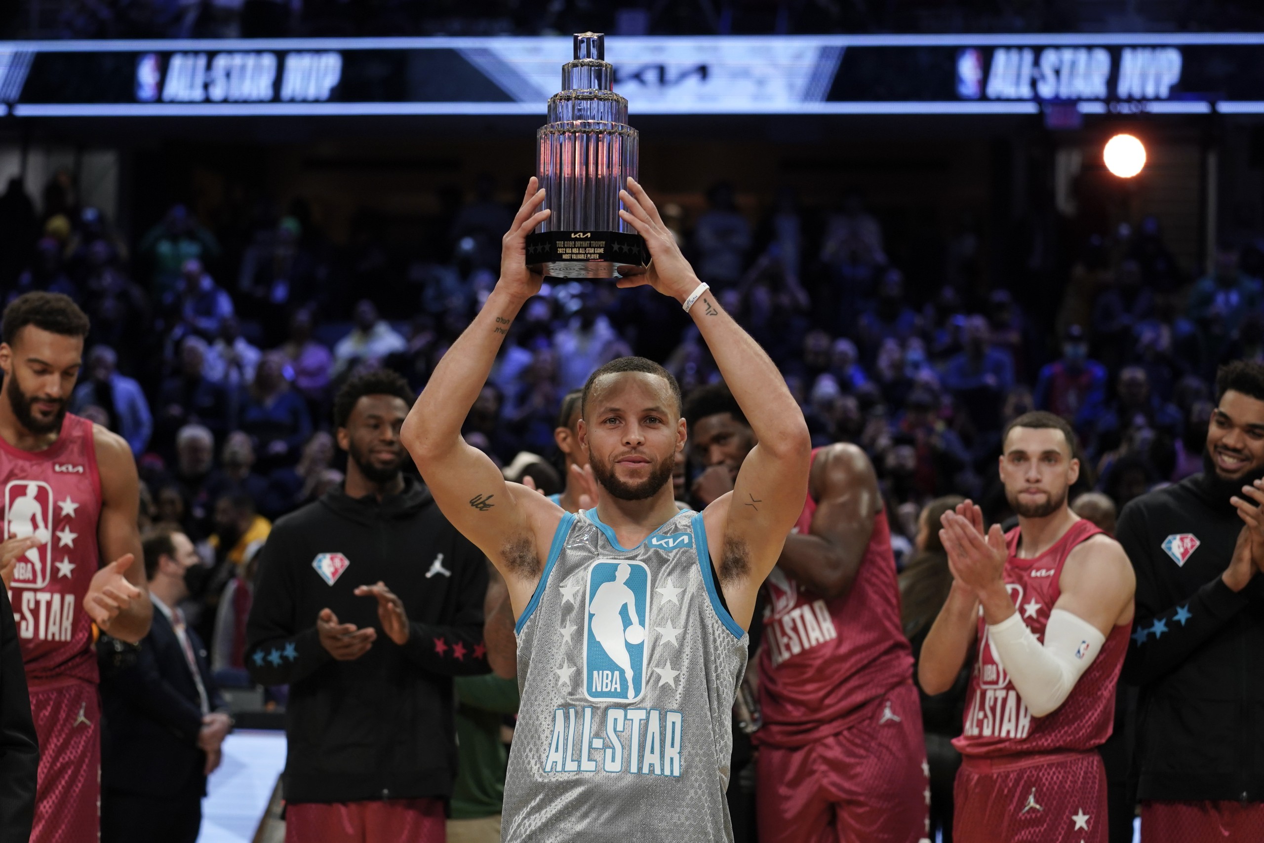 Golden State Warriors' Stephen Curry holds up the Kobe Bryant Trophy after being named the MVP of the NBA All-Star basketball game, Sunday, Feb. 20, 2022, in Cleveland. (AP Photo/Charles Krupa)