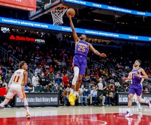 epa09726317 Phoenix Suns forward Mikal Bridges (C) shoots against Atlanta Hawks guard Trae Young (L) as Phoenix Suns guard Devin Booker (R) looks on during the first half of the NBA basketball game between the Phoenix Suns and the Atlanta Hawks at State Farm Arena in Atlanta, Georgia, USA, 03 February 2022.  EPA/ERIK S. LESSER  SHUTTERSTOCK OUT