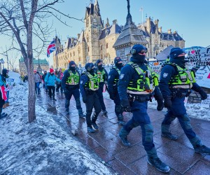 epa09754111 Policemen patrol near Parliament hill as truckers continue to protest in Ottawa, Canada, 13 February 2022. Truckers continue their protest against the mandate by the Canadian government for mandatory vaccines against COVID-19 to be able to return to Canada. A state of emergency was declared in the city of Ottawa on 06 February 2022 and policemen from Ottawa city, Ontario, and the Federal Royal Canadian Mounted Police (RCMP) are deployed.  EPA/VALERIE BLUM