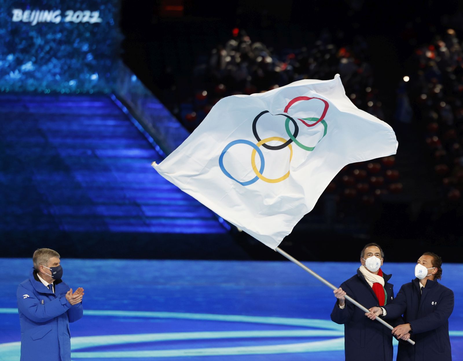 epa09774125 Milan Mayor Giuseppe Sala and his Cortina d’Ampezzo counterpart Gianpietro Ghedina wave the Olympic Flag next to International Olympic Committee (IOC) President Thomas Bach (L) during the Closing Ceremony for the Beijing 2022 Olympic Games at the National Stadium, also known as Bird's Nest, in Beijing China, 20 February 2022.  EPA/ROMAN PILIPEY