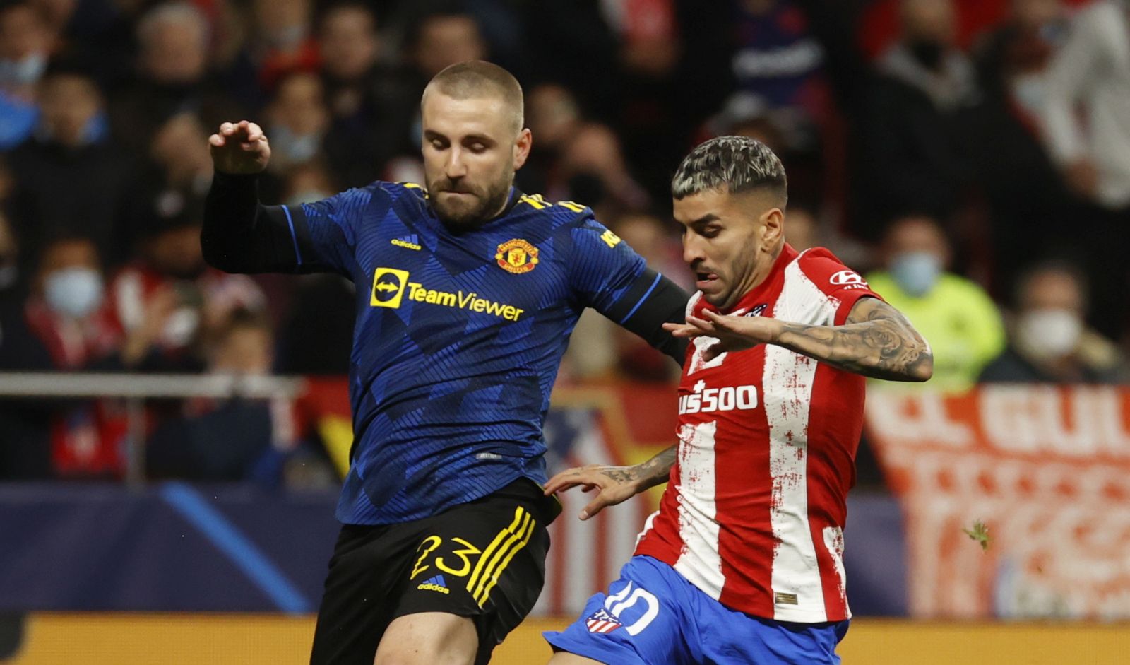 epa09779533 Atletico's Angel Correa (R) duels for the ball against Manchester United's Luke Shaw (L) during the UEFA Champions League round of 16 first leg soccer match between Atletico de Madrid and Manchester United held at Wanda Metropolitano stadium in Madrid, Spain, 23 February 2022.  EPA/Juanjo Martin
