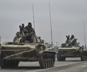epa09784384 Russian soldiers on the amphibious infantry fighting vehicle BMP-2 move towards mainland Ukraine on the road near Armiansk, Crimea, 25 February 2022. Russian troops entered Ukraine on 24 February prompting the country's president to declare martial law and triggering a series of announcements by Western countries to impose severe economic sanctions on Russia.  EPA/STRINGER