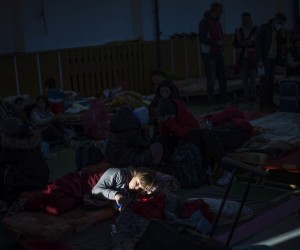epa09789827 A girl lits by sun from a window sits at school sport hall created as shelter as people fleeing Ukraine to Slovakia through the Ubla border crossing, in Ubla, Slovakia, 27 February 2022. Slovakia said it will let fleeing Ukrainians into the country following Russia's military operation in Ukraine. The Slovak Police Force announced on social media that people not holding a valid travel document will also be eligible for entry on an individual basis.  EPA/MARTIN DIVISEK