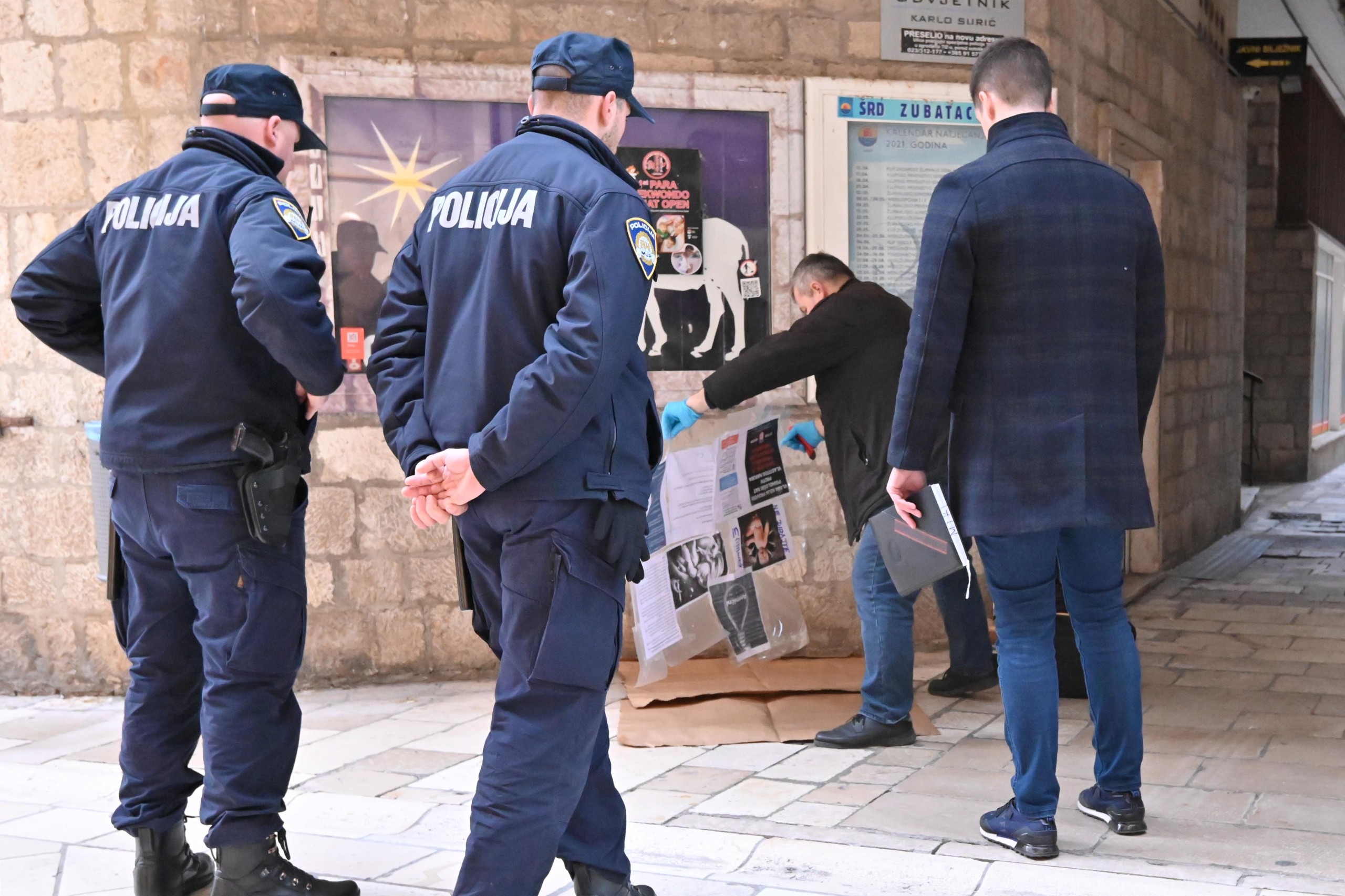21.12.2021., Zadar - Na oglasnoj ploci na Kalelargi djelatnici krim policije provode ocevid zbog plakata. Plakat je izuzet za krim obradu a na njemu je slika omce za vjesanje ispod koje je pisalo "anemicni". Photo: Dino Stanin/PIXSELL