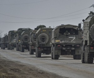 epa09784382 Russian troops move towards Ukraine on the road near Armiansk, Crimea, 25 February 2022. Russian troops entered Ukraine on 24 February prompting the country's president to declare martial law and triggering a series of announcements by Western countries to impose severe economic sanctions on Russia.  EPA/STRINGER