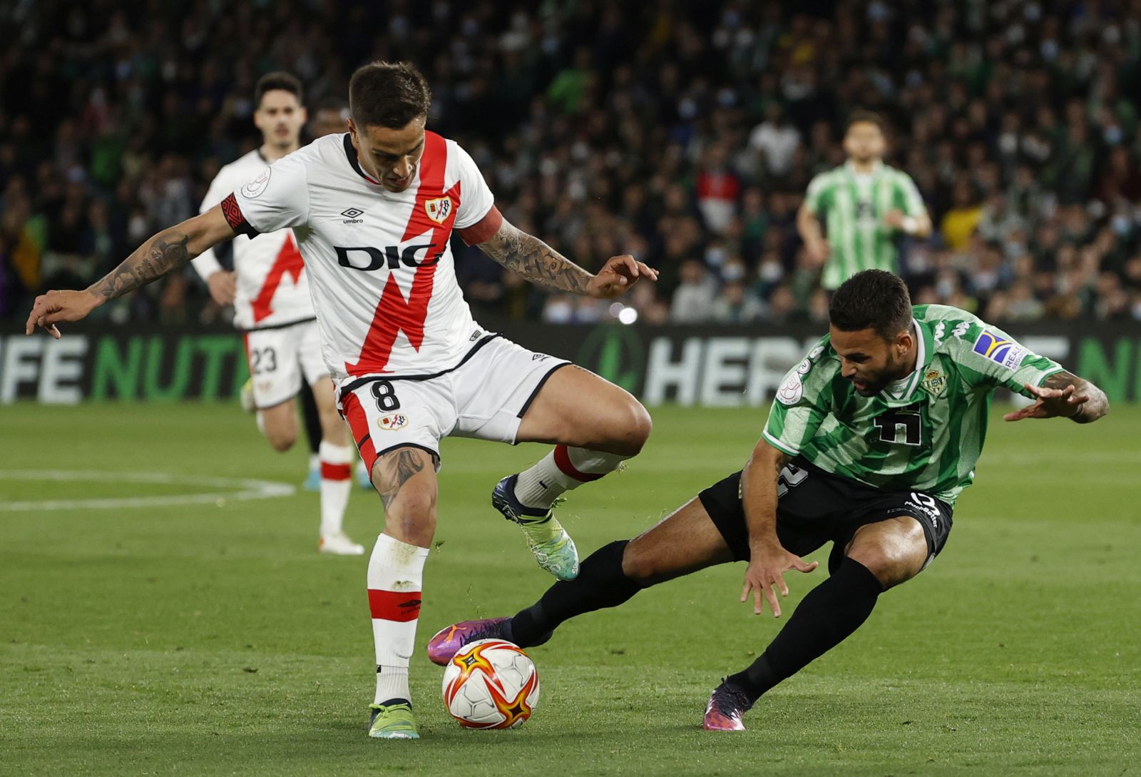 epa09799792 Real Betis' Willian Jose (R) in action against Rayo Vallecano's Oscar Trejo during the Spanish King's Cup semi final second leg soccer match between Real Betis and Rayo Vallecano at Benito Villamarin stadium in Sevilla, southern Spain, 03 March 2022.  EPA/JULIO MUNOZ