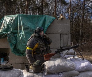 epa09810999 A member of the Ukrainian military stands guard at a checkpoint near Brovary, in the eastern frontline of Kyiv (Kiev) region, Ukraine, 08 March 2022. According to the United Nations High Commissioner for Refugees (UNHCR), Russia's military invasion of Ukraine, which started on 24 February, has destroyed civilian infrastructure and caused civilian casualties, with tens of thousands internally displaced and over two million refugees fleeing the country.  EPA/ROMAN PILIPEY