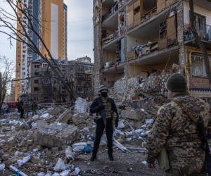 epa09834073 A policeman stands guard next to a destroyed residential building after shelling by the Russian military, in Podilskyi district, in Kyiv, Ukraine, 18 March 2022. One person has been reportedly killed and 19 injured during the shelling that happened in the morning. On 24 February Russian troops had entered Ukrainian territory in what the Russian president declared a 'special military operation', resulting in fighting and destruction in the country, a huge flow of refugees, and multiple sanctions against Russia.  EPA/ROMAN PILIPEY