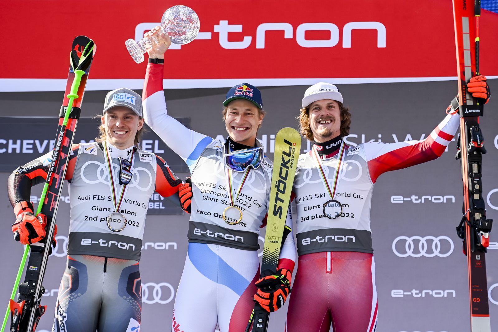 epa09835759 (L-R) - Second placed Henrik Kristoffersen of Norway, winner Marco Odermatt of Switzerland and third placed Manuel Feller of Austria celebrate on the podium of the men's Giant-Slalom overall leader's trophy at the FIS Alpine Skiing World Cup finals in Meribel, France, 19 March 2022.  EPA/URS FLUEELER