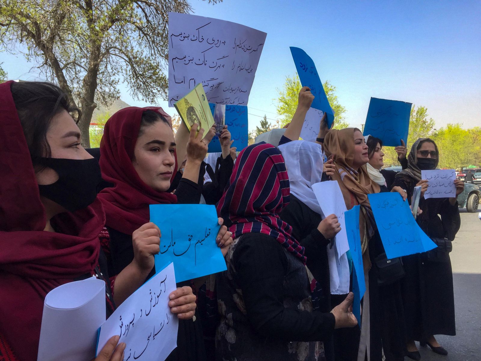 epa09850648 Afghan teachers hold placads during a protest near the main entrance of the ministry of education for raising their voices for their education rights and reopening the secondary and high schools for girls in Kabul, Afghanistan, 26 March 2022. The Taliban on 23 March barred girls of grades seven to 12 from attending schools pending a decision on their uniform designs according to Islamic law, in a sudden departure from their earlier announcement that all Afghan females would be allowed to attend classes this week. Allowing girls of all ages to attend schools has been one of the most crucial demands set by the international community after the Taliban, came to power.  EPA/STRINGER