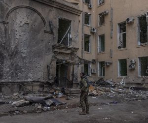 epa09853210 A member of the Ukrainian military stands next to the damaged building of Kharkiv Regional State Administration, that was heavily shelled by Russian forces, in Kharkiv, northeast Ukraine, 27 March 2022. The building was heavily shelled on 01 March, and the searching operation for victims is still going on. The bodies of 24 people have been found under the rubble, according to the information provided by Ukrainian State Emergency Service. Kharkiv, Ukraine’s second-largest city of 1.5 million people, which lies about 25 miles from the Russian border, has been heavily shelled by Russian forces over the past weeks, with many civilians killed in the city.  EPA/ROMAN PILIPEY