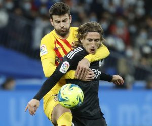 epa09839323 Real Madrid's Luka Modric (R) in action against FC Barcelona's Gerard Pique (L) during 'El Clasico', the Spanish LaLiga soccer match between Real Madrid and FC Barcelona in Madrid, Spain, 20 March 2022.  EPA/Juanjo Martin