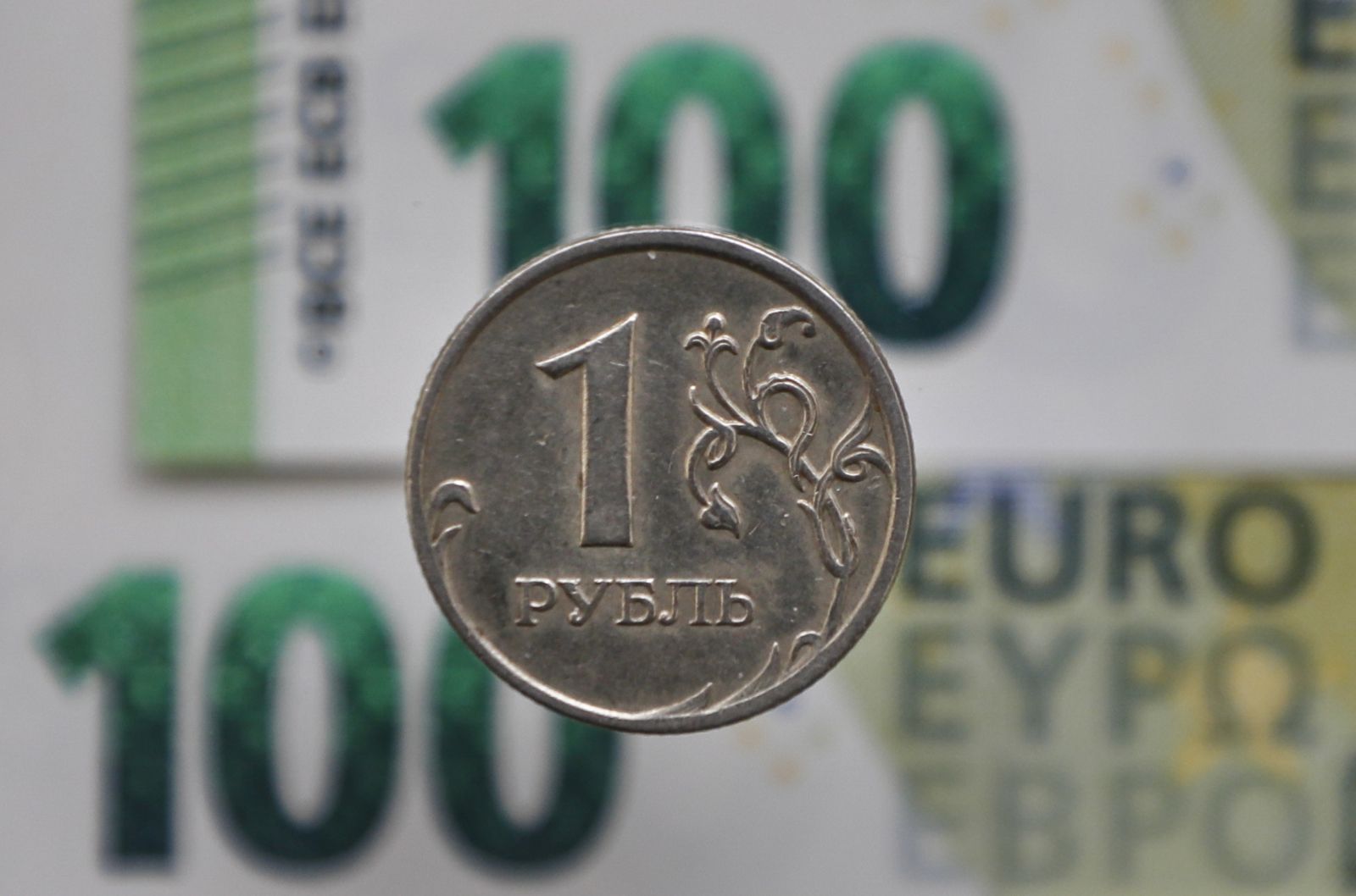 epa09863443 A photo illustration shows a Russian ruble coin and one hundred euro banknotes in Moscow, Russia, 01 April 2022. Russian President Putin announced on 31 March that he signed a decree on transitioning to payments for Russian natural gas in rubles for 'unfriendly countries' starting from 01 April, threatening supply disruption unless target nations comply. The decree would require foreign buyers of Russian gas to open an account at Russia's Gazprombank and transfer euros or US dollars into it.  EPA/YURI KOCHETKOV