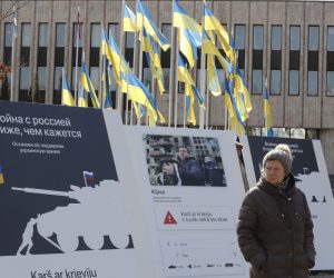 epa09864183 A woman looks at photo exhibition created by Ukrainian graphic designers and text creators in front to the Russian Embassy in Riga, Latvia, 01 April 2022. According to the designers, the exhibition is meant to send a message that the war is closer than it seems.  EPA/TOMS KALNINS