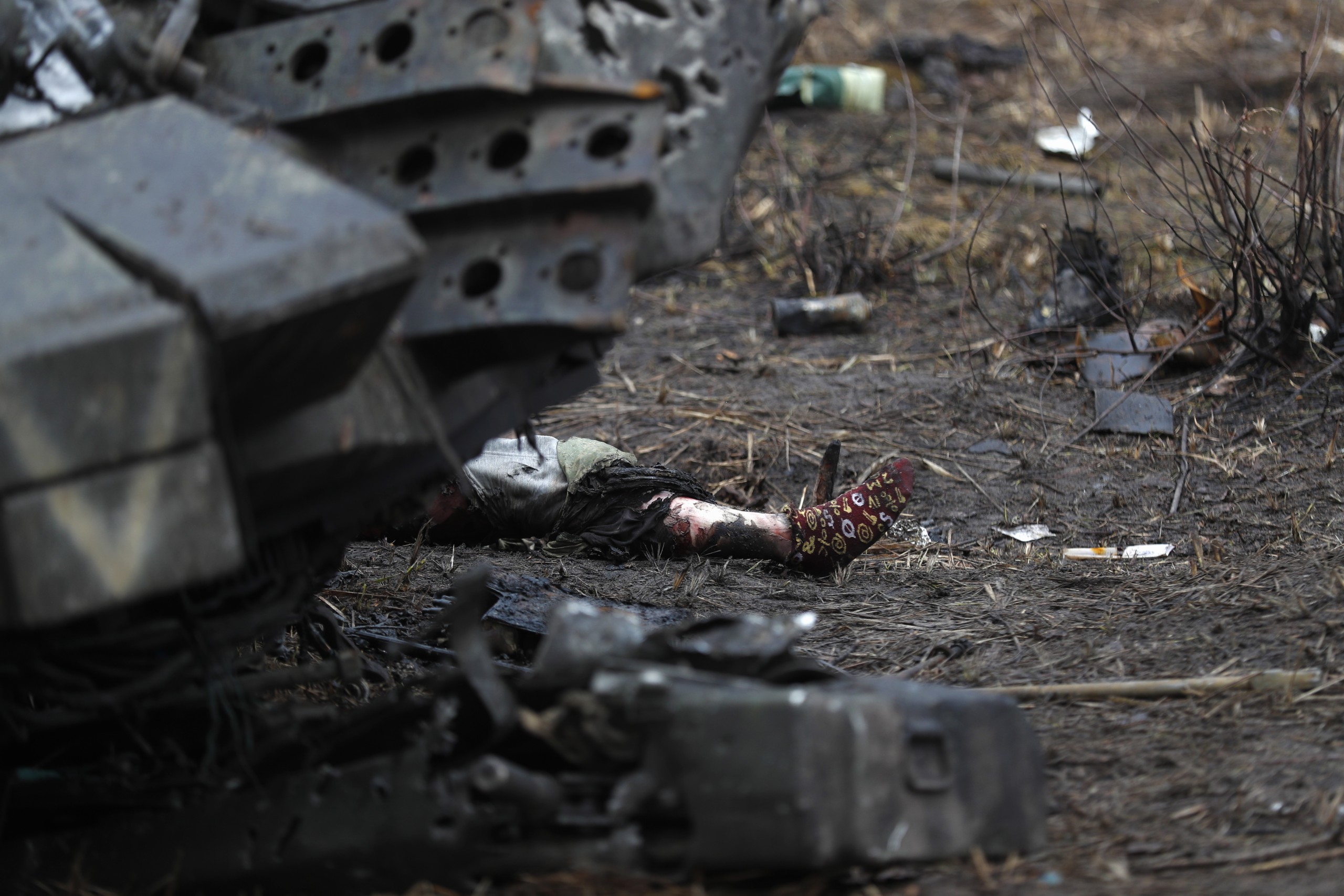 epa09868262 A body of Russian soldier lies next to a burned  tank in the village of Dmitrivka near Kyiv, Ukraine, 03 April 2022. Dmitrivka and the area around had recently been recaptured by the Ukrainian army from Russian forces. On 24 February, Russian troops had entered Ukrainian territory in what the Russian president declared a 'special military operation', resulting in fighting and destruction in the country, a huge flow of refugees, and multiple sanctions against Russia.  EPA/ATEF SAFADI ATTENTION EDITORS: GRAPHIC CONTENT