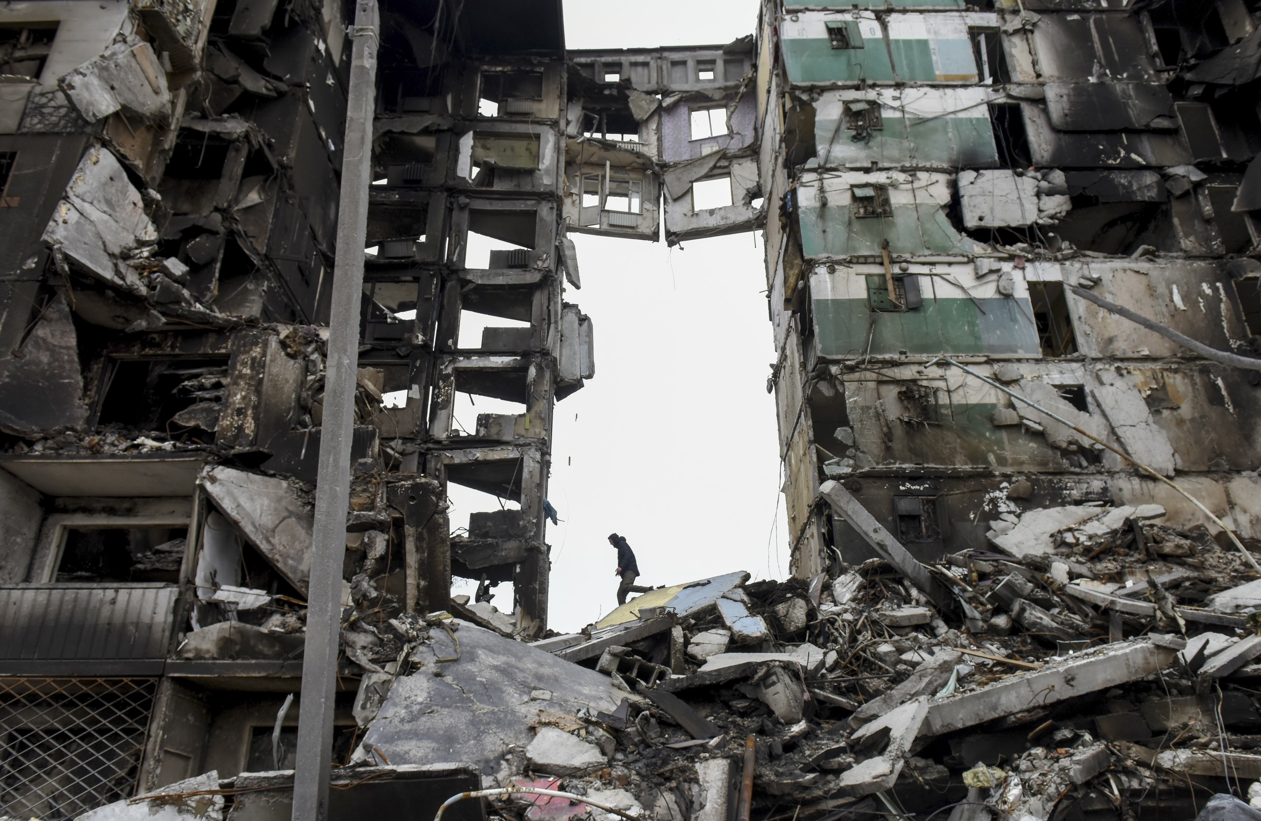 epaselect epa09872658 A man climbs on the destroyed apartment block in the city of Borodyanka near Kyiv (Kiev), Ukraine, 05 April 2022. On 24 February, Russian troops had entered Ukrainian territory in what the Russian president declared a 'special military operation', resulting in fighting and destruction in the country, a huge flow of refugees, and multiple sanctions against Russia.  EPA/OLEG PETRASYUK