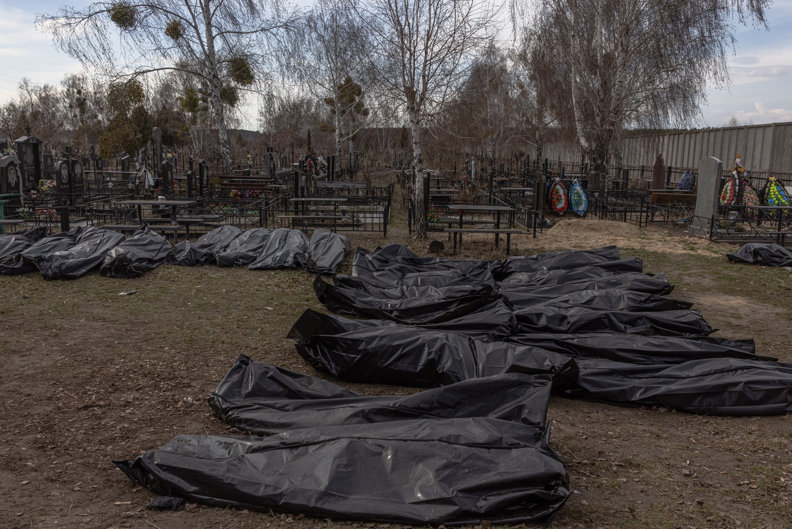 epa09876886 Bodies of killed people, which were brought to the cemetery, lay on the ground in body bags, in Bucha, northwest of Kyiv, Ukraine, 07 April 2022. Hundreds of tortured and killed civilians have been found in Bucha and other parts of the Kyiv region after the Russian army retreated from those areas. The growing evidence shows that the Russian forces are believed to be behind the atrocities when they were controlling the areas. Russian troops entered Ukraine on 24 February resulting in fighting and destruction in the country and triggering a series of severe economic sanctions on Russia by Western countries.  EPA/ROMAN PILIPEY