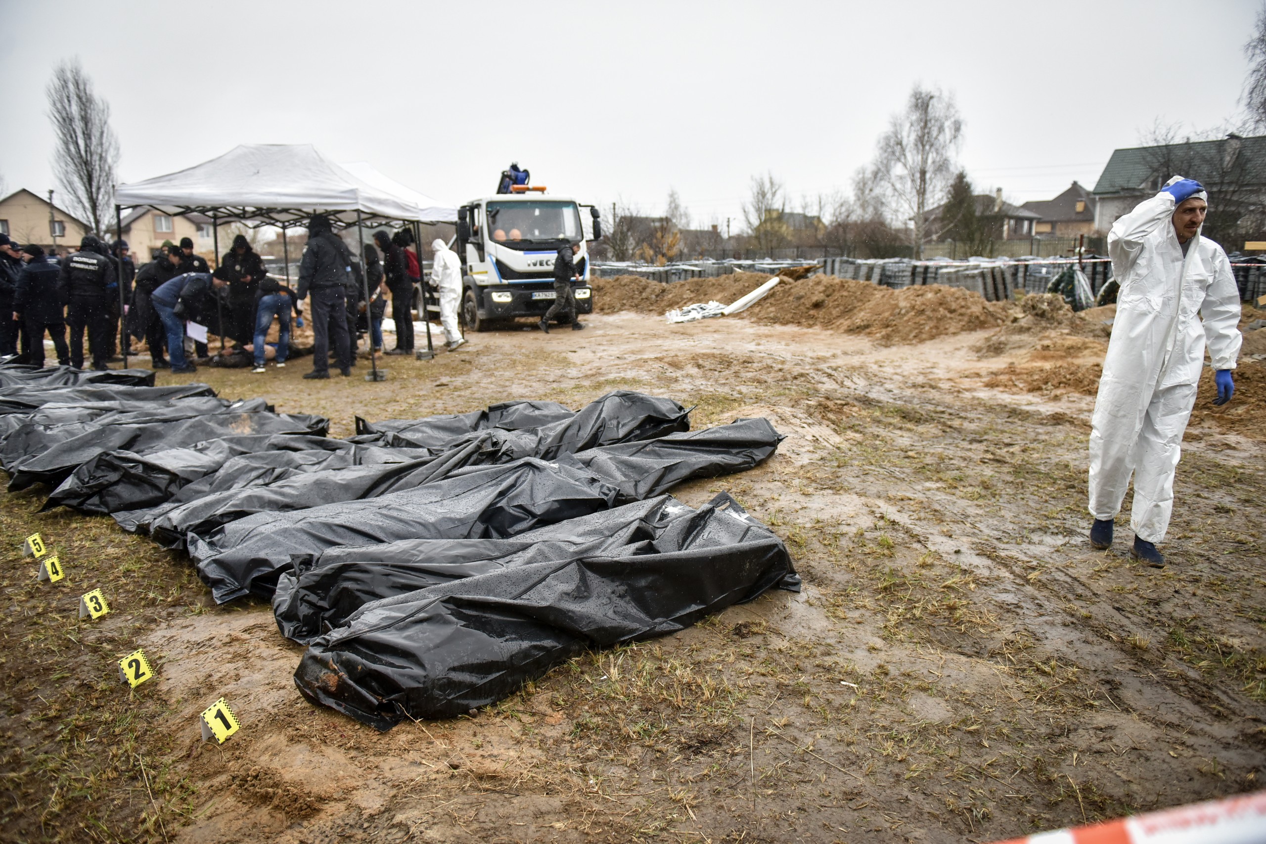 epa09878617 Forensic police officers exhume bodies from a mass grave discovered in Bucha, outskirts of Kyiv (Kiev), Ukraine, 08 April 2022. Ukrainian authorities say that over 400 bodies were discovered following the Russian army’s retreat from towns surrounding Kyiv, prompting international calls for a probe into possible war crimes committed by Russia.  EPA/OLEG PETRASYUK