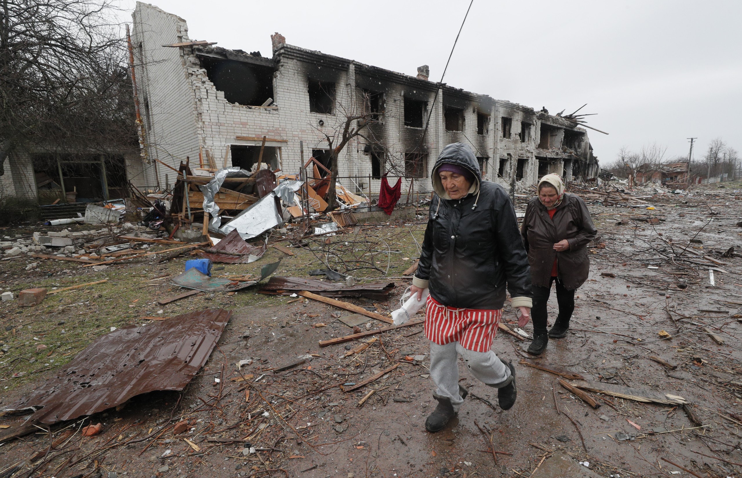 epa09881328 Locals walk by a shelled street on the outskirt of Chernihiv city which was blocked by Russian troops for a long time, Ukraine, 09 April 2022.  Some cities and villages had recently been recaptured by the Ukrainian army from Russian forces and now people try to restore normal life there. Russian troops entered Ukraine on 24 February resulting in fighting and destruction in the country and triggering a series of severe economic sanctions on Russia by Western countries.  EPA/SERGEY DOLZHENKO