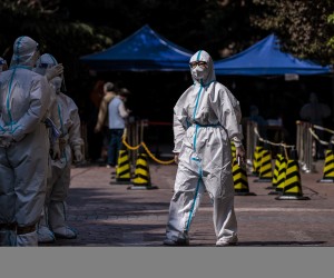 epa09885371 Security members and police in protective gear stand in a residential community under lockdown in Shanghai, China, 12 April 2022. Shanghai authorities announced, on 12 April, the release of some residential areas without coronavirus cases from Covid-19 lockdown, while the majority are still closed with residents reportedly complaining about food shortages.  EPA/ALEX PLAVEVSKI