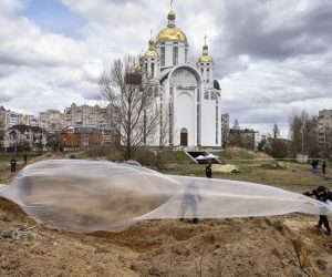 epaselect epa09885933 Police officers cover a mass grave with a plastic sheet as members of an international team of war crimes prosecutors and the Prosecutor General of Ukraine visit a mass grave in Bucha, Kyiv (Kiev) area, Ukraine, 12 April 2022. Forensic investigators began exhuming a mass grave in Bucha containing more than 410 bodies of civilians, according to Ukrainian officials. The UN Human Rights Council has decided to launch an investigation into the violations committed after Russia's full-scale invasion of Ukraine, the Ukrainian Parliament reported. Russian troops entered Ukraine on 24 February resulting in fighting and destruction in the country and triggering a series of severe economic sanctions on Russia by Western countries.  EPA/OLEG PETRASYUK