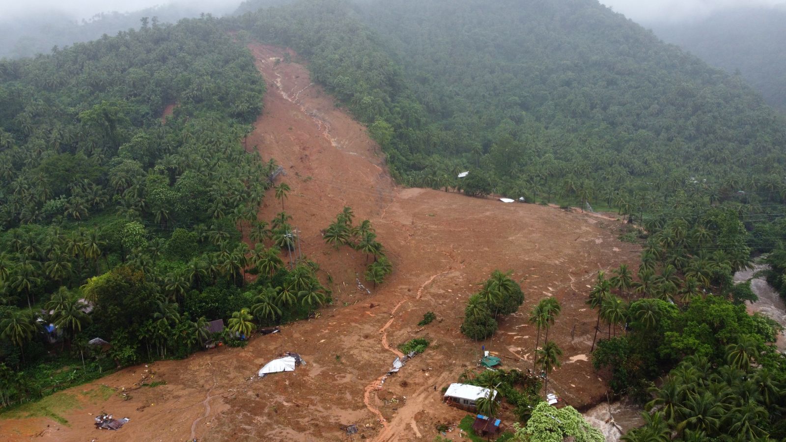 epa09887998 A photo taken with a drone shows a collapsed mountain side and buried houses in Bunga village, Baybay city, Leyte island, Philippines, 12 April 2022 (issued 13 April 2022). According to the National Disaster Risk Reduction and Management Council (NDRRMC), the death toll, on April 13, rose to 63 and over 100 people were injured while 27 are missing brought about by Typhoon Megi. Megi is the first weather disturbance to hit the country in 2022.  EPA/DELPHI ALLERA BEST QUALITY AVAILABLE