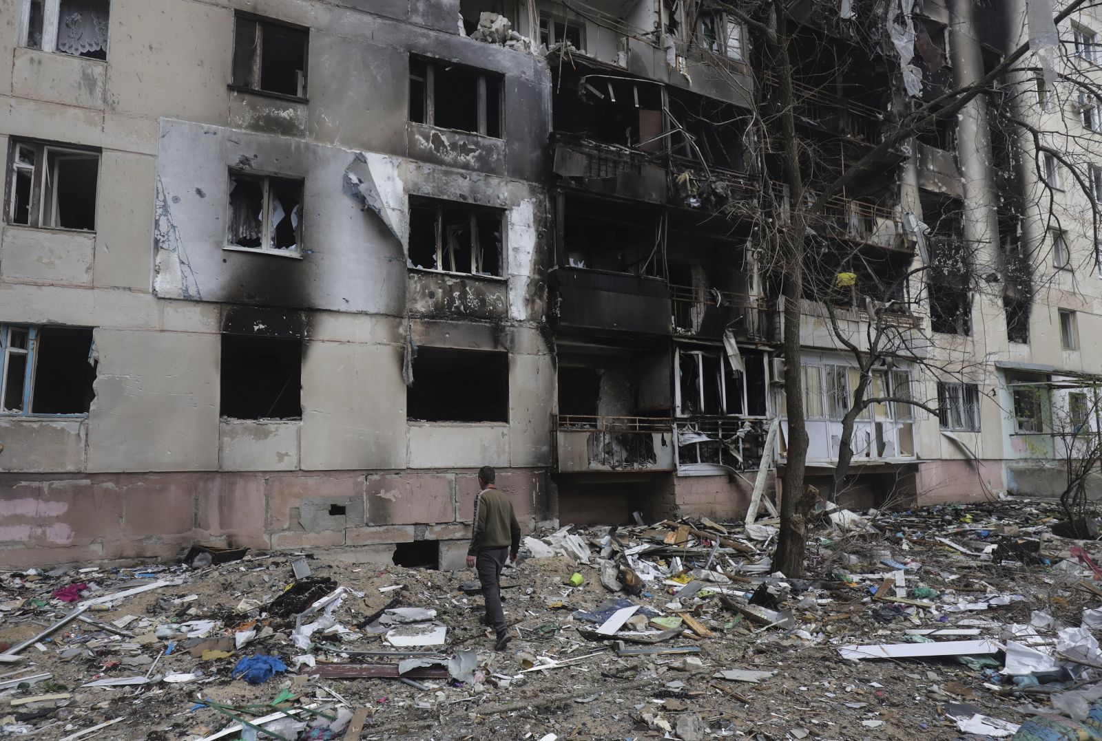 epa09893604 A man walks past a residential building damaged during a shelling in Severodonetsk, North-West of Luhansk, Ukraine, 16 April 2022. Russian troops entered Ukraine on 24 February resulting in fighting and destruction in the country and triggering a series of severe international economic sanctions on Russia.  EPA/STR
