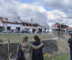 epaselect epa09895738 People look as Ukrainian rescuers put out a fire of an auto service center after Russian shelling in the western Ukrainian city of Lviv, Ukraine, 18 April 2022. According to Lviv authorities, seven civilians were killed and eleven people injured as Russian troops shelled Lviv's civilian infrastructure.  EPA/MYKOLA TYS