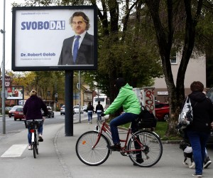 epa09900620 Citizens pass near by a huge pre election poster in downtown Ljubljana, Slovenia, 21 April 2022. Slovenia's parliamentary elections will be held on 24 April 2022.  EPA/ANTONIO BAT