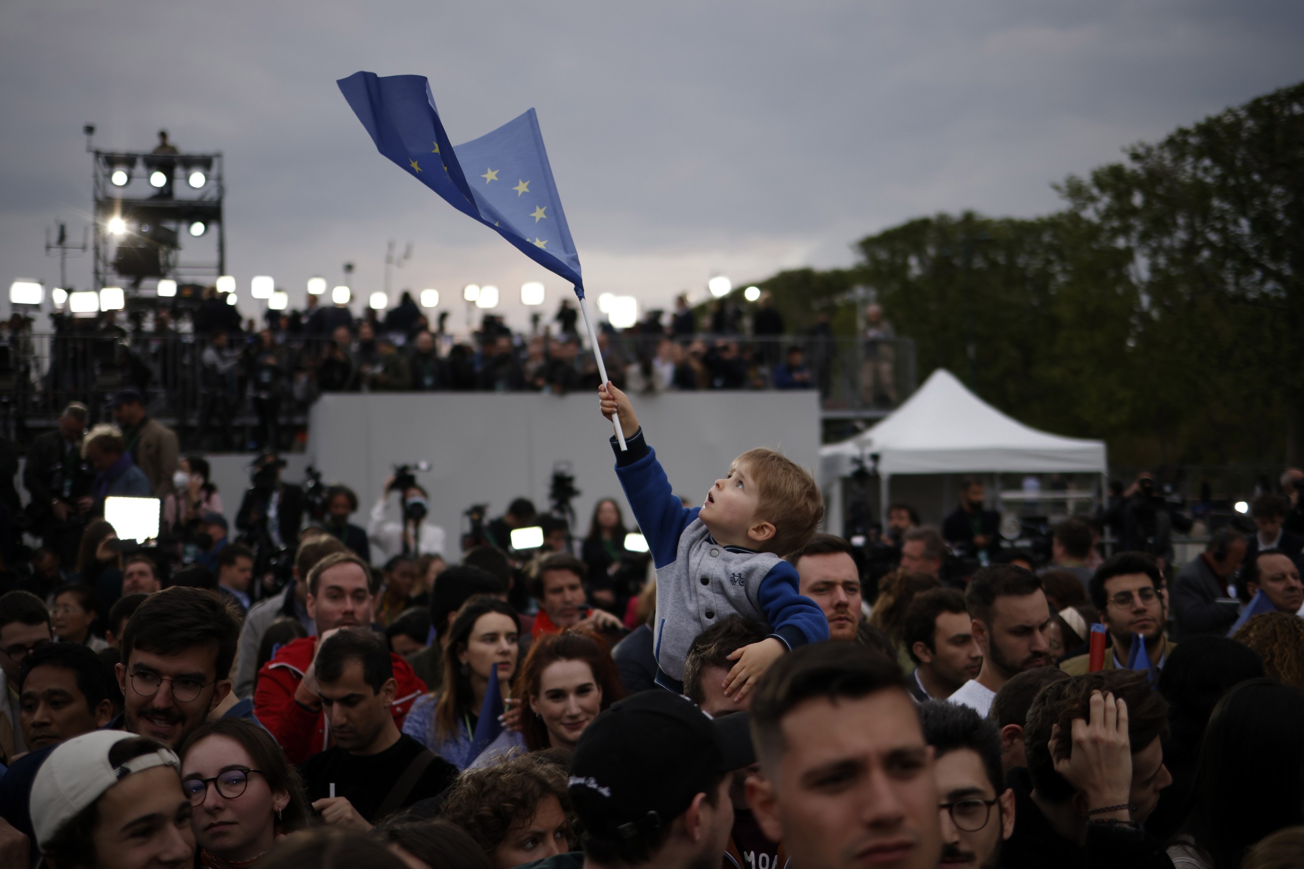epa09907231 Supporters of French President and candidate for re-election Emmanuel Macron (not pictured) celebrate at the Champs-de-Mars after Emmanuel Macron won the second round of the French presidential elections in Paris, France, 24 April 2022. Emmanuel Macron defeated Marine Le Pen in the final round of France's presidential election, with exit polls indicating that Macron is leading with approximately 58 percent of the vote.  EPA/YOAN VALAT