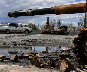 epa09913414 A car, damaged by shelling, passes destroyed armored vehicles in Kolychivka village, Chernihiv region, 27 April 2022. On 24 February, Russian troops entered Ukrainian territory in what the Russian president declared a 'special military operation', resulting in fighting and destruction in the country, a huge flow of refugees, and multiple sanctions against Russia.  EPA/OLEG PETRASYUK