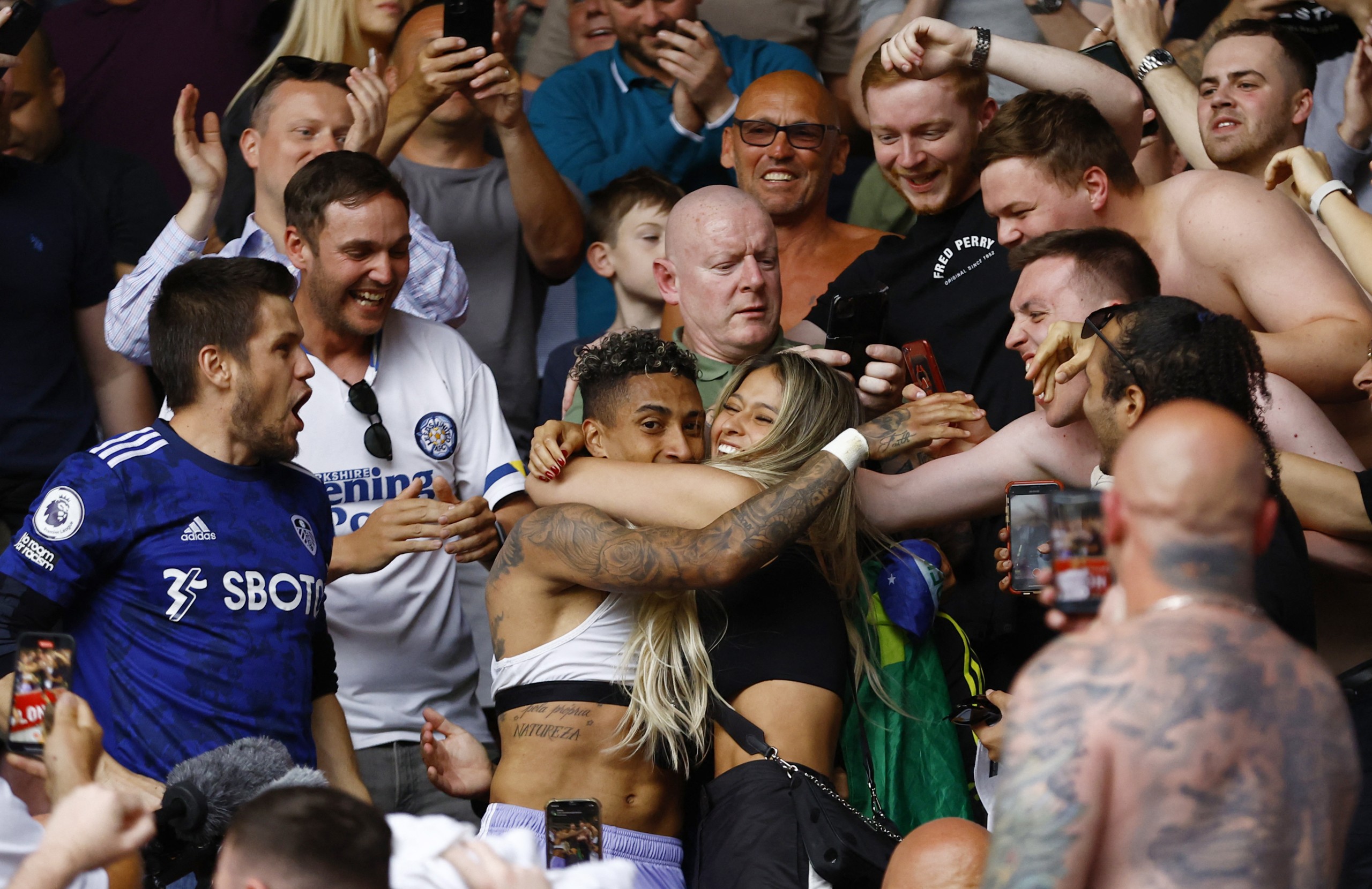 Soccer Football - Premier League - Brentford v Leeds United - Brentford Community Stadium, London, Britain - May 22, 2022 Leeds United's Raphinha celebrates with family and fans in the stands after the match as Leeds United avoid relegation from the Premier League Action Images via Reuters/Andrew Boyers EDITORIAL USE ONLY. No use with unauthorized audio, video, data, fixture lists, club/league logos or 'live' services. Online in-match use limited to 75 images, no video emulation. No use in betting, games or single club /league/player publications.  Please contact your account representative for further details.