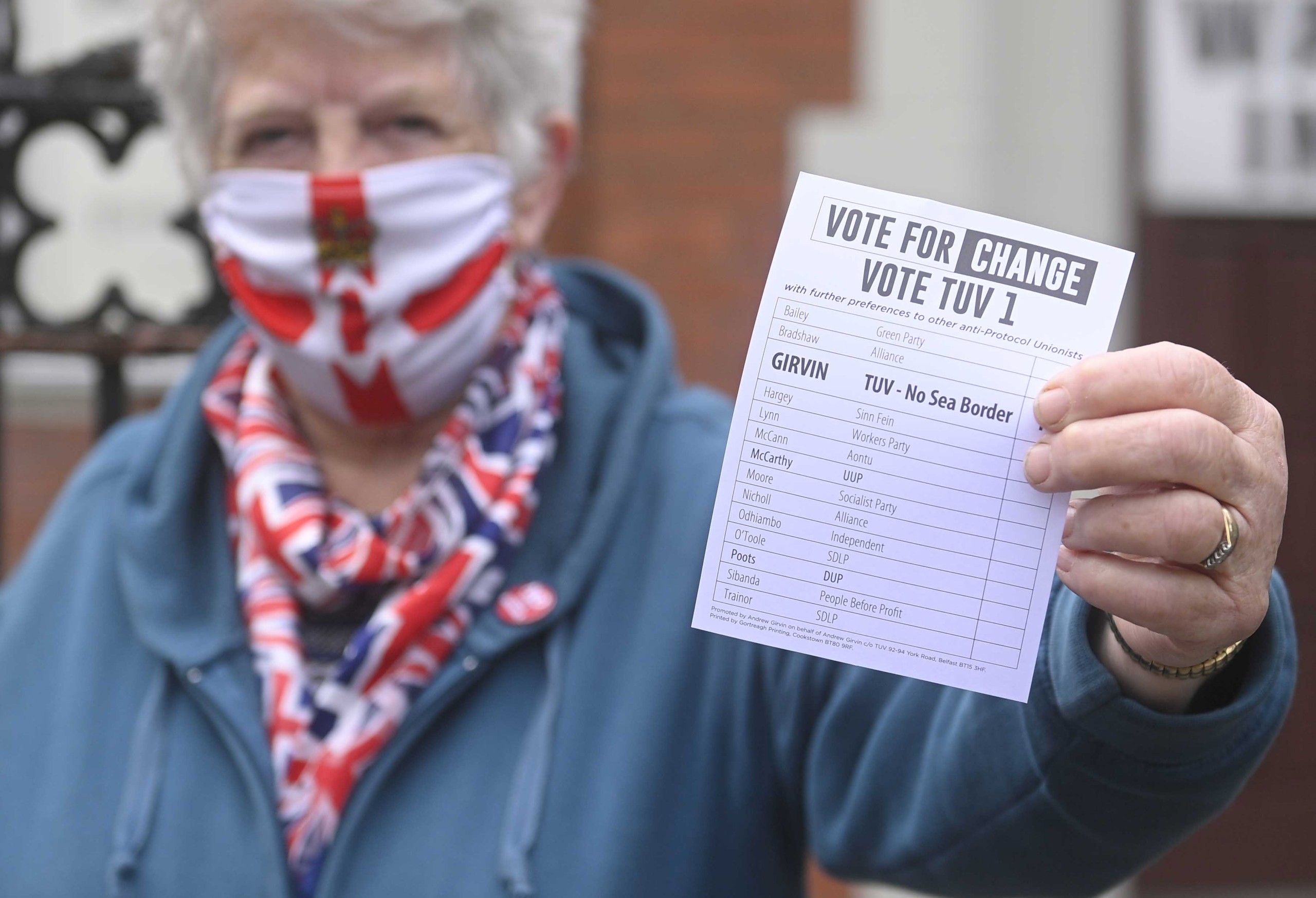 epa09928561 A woman hands out leaflets in support of the TUV [Traditional Unionist Voice] in Belfast, Northern Ireland, 05 May 2022.  Polling stations across Northern Ireland are open for voting for the 2022 Assembly Election.  EPA/MARK MARLOW