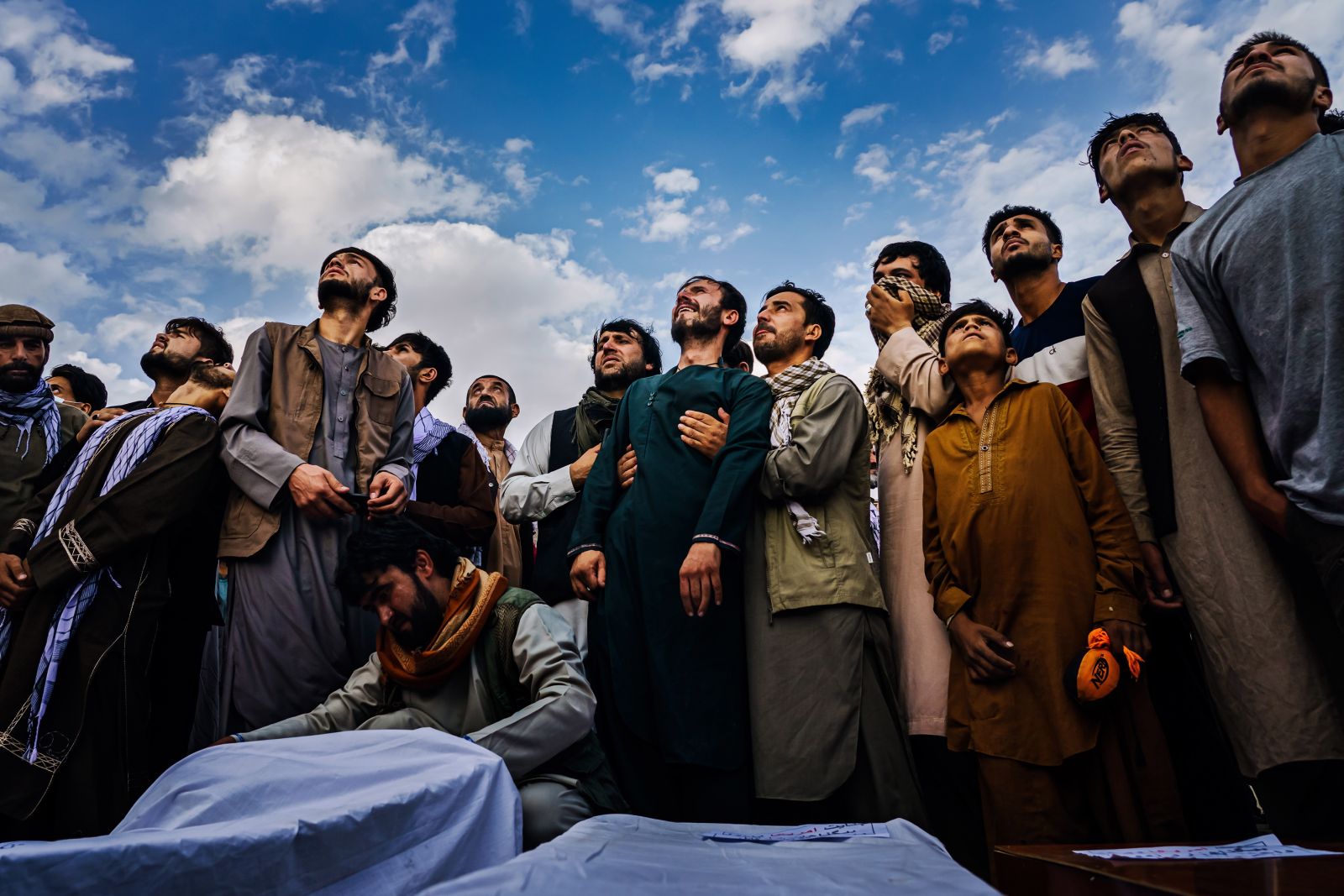 epa09936796 A handout photo made available by the Los Angeles Times of Marcus Yam's images on the fall of Afghanistan for which he won the  Pulitzer Prize for breaking news photography:

Mourners at a mass funeral look up and weep as the roar of jet engines drown out their wails in Kabul, Afghanistan, on Aug. 30, 2021. Fighter jets circled the hilltop cemetery where members of the Ahmadi family were burying 10 of their own - seven of them children - all victims of a U.S. drone strike. A full day before the U.S. military withdrawal approached its conclusion, death continued to haunt the war-torn country. The airstrike came in the wake of an airport bombing on Aug. 26 carried out by ISIS-K militants. The United States military claimed initially that it was targeting an alleged Islamic extremist who posed the threat of carrying out a similar attack. A month later, it reversed its position, but the Pentagon decided no American troops would be punished. Left to grieve and wonder, Emal Ahmadi could not understand how it could be that a family could die and no one be held accountable.  EPA/Marcus Yam / HANDOUT only to be used with reporting on 2022 Pulitzer Prize HANDOUT EDITORIAL USE ONLY/NO SALES/NO ARCHIVES