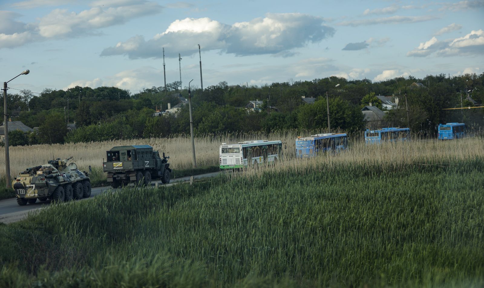 epa09953880 Russian militrary vehicles escort buses carrying Ukrainian servicemen that are being evacuated from the besieged Azovstal steel plant in Mariupol, Ukraine, 17 May 2022. A total of 265 Ukrainian militants, including 51 seriously wounded, have laid down arms and surrendered to Russian forces, the Russian Ministry of Defence said on 17 May 2022. Those in need of medical assistance were sent for treatment to a hospital in Novoazovsk, the ministry states further. Russian President Putin on 21 April 2022 ordered his Defence Minister to not storm but to blockade the plant where a number of Ukrainian fighters were holding out. On 24 February, Russian troops invaded Ukrainian territory starting a conflict that has provoked destruction and a humanitarian crisis. According to the UNHCR, more than six million refugees have fled Ukraine, and a further 7.7 million people have been displaced internally within Ukraine since.  EPA/ALESSANDRO GUERRA