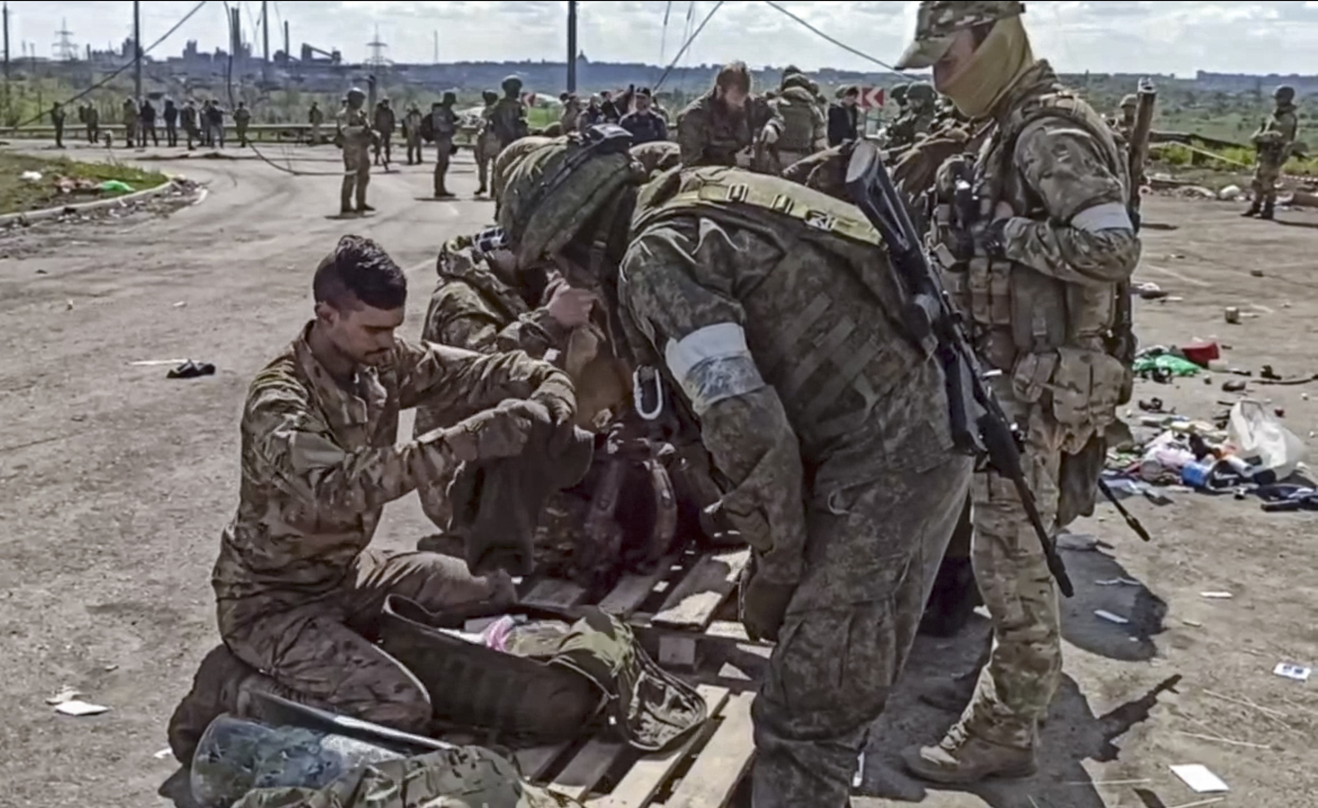 epa09962235 A still image taken from handout video made available on 21 May 2022 by the Russian Defence Ministry's press service shows Russian servicemen frisking Ukrainian servicemen evacuated from the besieged Azovstal steel plant in Mariupol, Ukraine, 20 May 2022 (issued 21 May 2022). The Chief spokesman of the Russian Defense Ministry, Major General Igor Konashenkov, said on 20 May that the Azofstal steel plant is now under full Russian army control. Russian troops entered Ukraine on 24 February 2022.  EPA/RUSSIAN DEFENCE MINISTRY PRESS SERVICE/HANDOUT BEST QUALITY AVAILABLE HANDOUT EDITORIAL USE ONLY/NO SALES