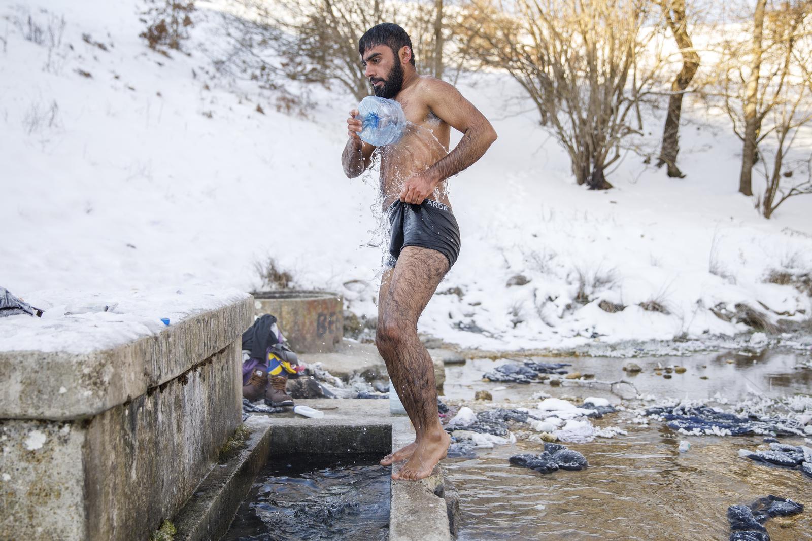 15.01.2021., Bihac, Bosna i Hercegovina - Tekuce vode u migrantskom kampu Lipa u blizini Bihaca jos uvijek nema. Ono malo vode u rezervoarima se jutros zaledilo jer je temperatura u 9 sati bila -14 stupnjava Celzija. Migrantu iz Pakistana Hagiazu Abdulrehmanu kupanje u obliznjem potoku jedina je mogucnost za odrzavanje osobne higijene. Prema pisanju lokalnih medija kamp Lipa bit ce u potpunosti funkcionalan tek za 3 mjeseca..Photo: Armin Durgut/PIXSELL