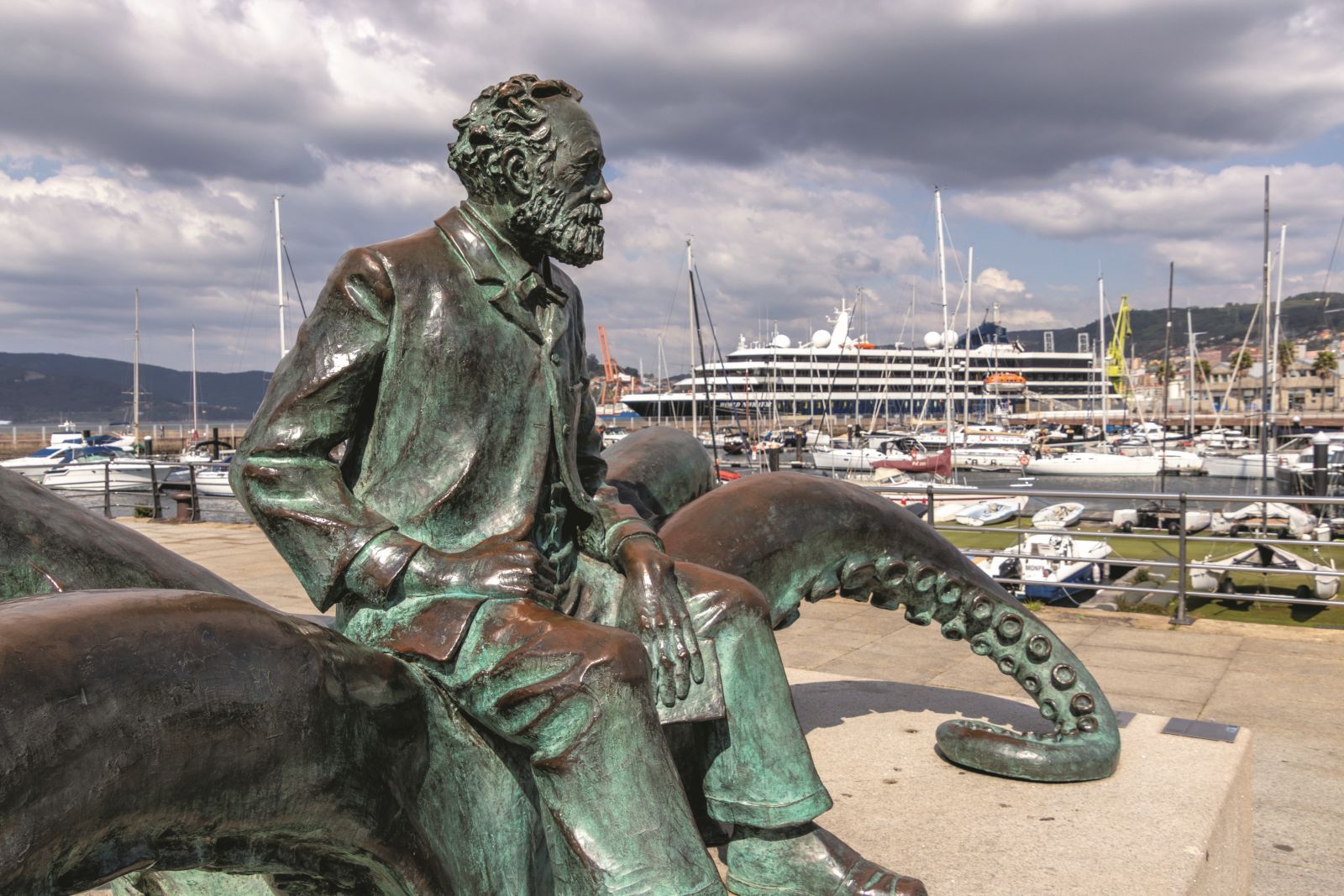 Vigo, Spain - Apr 25, 2020: Statue of french writer Jules Verne with a book sitting on an octopus in the port of Vigo