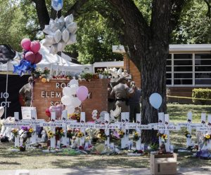 epa09978423 Crosses bearing names of victims line an area on school ground following a mass shooting at the Robb Elementary School in Uvalde, Texas, USA, 26 May 2022. According to Texas officials, at least 19 children and two adults were killed in the shooting on 24 May. The eighteen-year-old gunman was killed by responding officers.  EPA/TANNEN MAURY