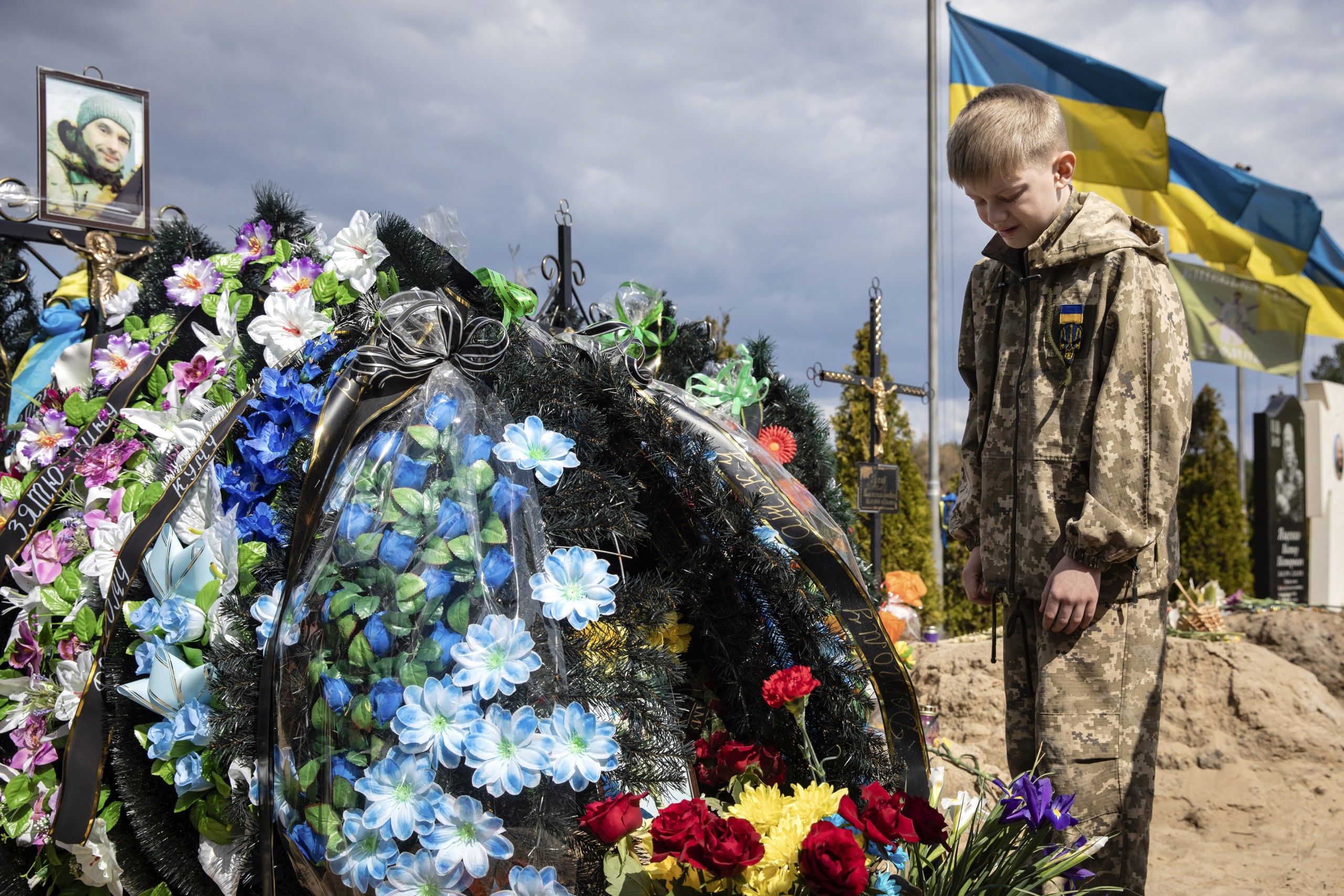 epa09991177 (FILE) - Ten-year-old Savelii reacts at his father's grave, who died defending Irpin as a member of territorial defense forces, in Irpin, Ukraine, 01 May 2022 (reissued 03 June 2022). 04 June 2022 marks 100 days since on 24 February 2022 Russian troops invaded Ukrainian territory in what the Russian president declared a "Special Military Operation", starting an armed conflict that has provoked destruction and a humanitarian crisis. According to the UNHCR, more than 6.8 million refugees have fled Ukraine, and a further 7.7 million people have been displaced internally within Ukraine since. The Russian invasion was met by Western countries with heavy economic sanctions against Russian companies and individuals, as well as weaponry deliveries and financial support to Ukraine.  EPA/MIKHAIL PALINCHAK  ATTENTION: This Image is part of a PHOTO SET *** Local Caption *** 57649678