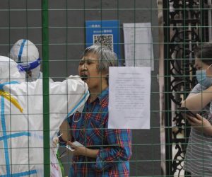 epa10007298 A woman in quarantine takes PCR Coronavirus test, amid new round of COVID-19 lockdowns and cases, in Shanghai, China, 11 June 2022. Shanghai starts weekend PCR screening to curb rising community COVID-19 cases. Only 10 days after the city lifted the 2-month lockdown in order to eliminate the community spread of COVID-19, residents of 15 out of 16 districts will need to participate in mandatory PCR testing this weekend. Shanghai city reported 7 locally transmitted COVID-19 cases and 9 local asymptomatic infections, according to the Shanghai Health Commission on 11 June 2022.  EPA/ALEX PLAVEVSKI