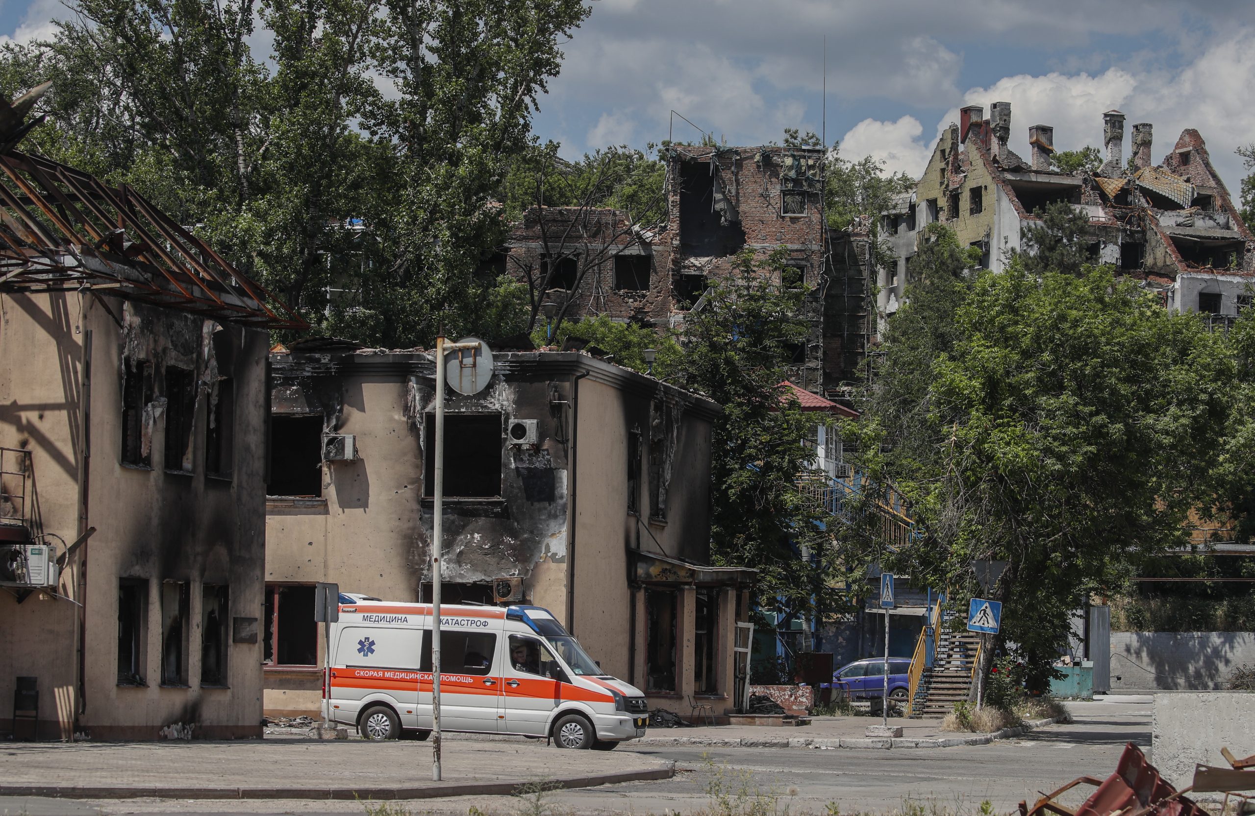 epa10009867 A picture taken during a visit to Mariupol organized by the Russian military shows an ambulance on a street in the cargo sea port of Mariupol, Ukraine, 12 June 2022. Russian Defense Minister Sergei Shoigu said the seaports of Mariupol and Berdyansk in Ukraine are operating normally and are ready to ship grain.  According to Shoigu, demining of the Mariupol seaport has been completed and it is functioning normally and has received the first cargo ships. Shoigu added ‘In Mariupol, water and electricity supply to residential areas are gradually being restored, streets are being cleared, the first social facilities have begun to function.’ On 24 February Russian troops entered Ukrainian territory starting a conflict that has provoked destruction and a humanitarian crisis. According to the UNHCR, more than six million refugees have fled Ukraine, and a further 7.7 million people have been displaced internally within Ukraine since.  EPA/SERGEI ILNITSKY