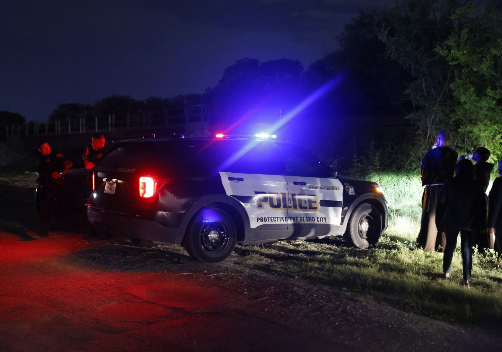 epa10037771 Police and officials man a roadblock near a tractor trailor on the side of the road leading to the location where more at least 46 migrants were reportedly found dead along with at least 15 who were still alive, on a roadway near railroad tracks in San Antonio, Texas, USA, 28 June 2022.  EPA/ADAM DAVIS