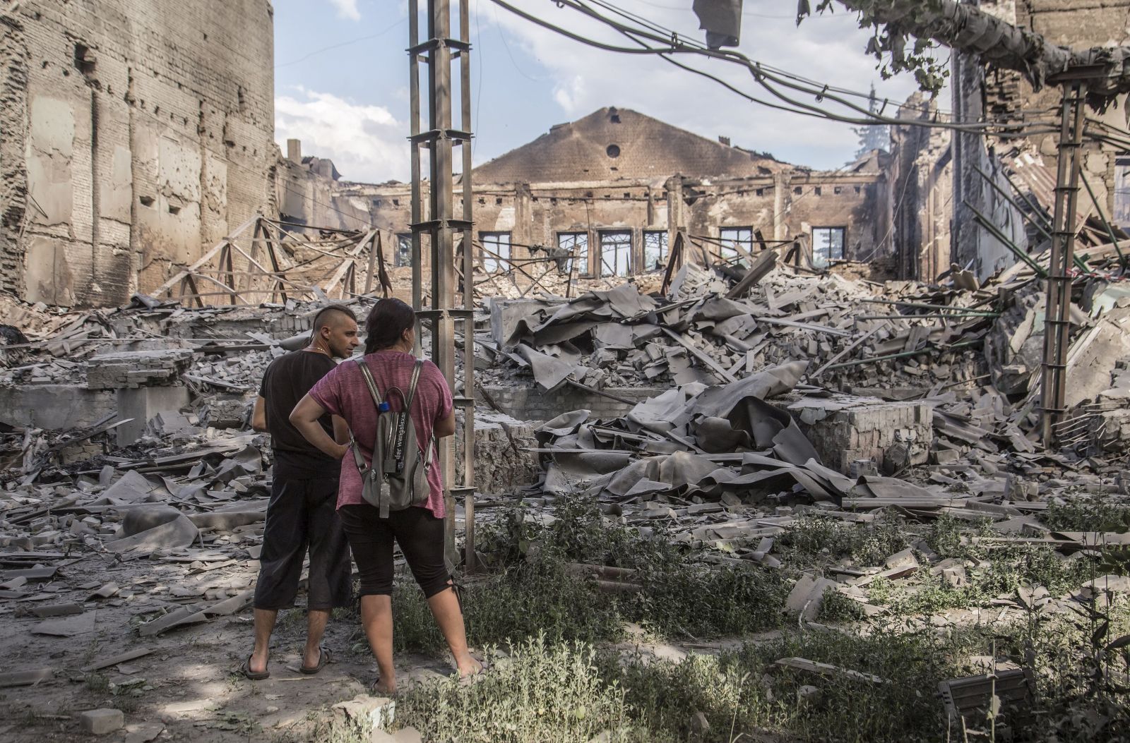 epa10020919 Locals look at destroyed buildings in Lysychansk after heavy fighting in the Luhansk area, Ukraine, 18 June 2022, five kilometers north-east of Severodonetsk. The city and its surroundings have turned into a battlefield in the past weeks. Russian troops on 24 February had invaded Ukraine, starting a conflict that provoked death, destruction and a humanitarian crisis ever since.  EPA/OLEKSANDR RATUSHNIAK